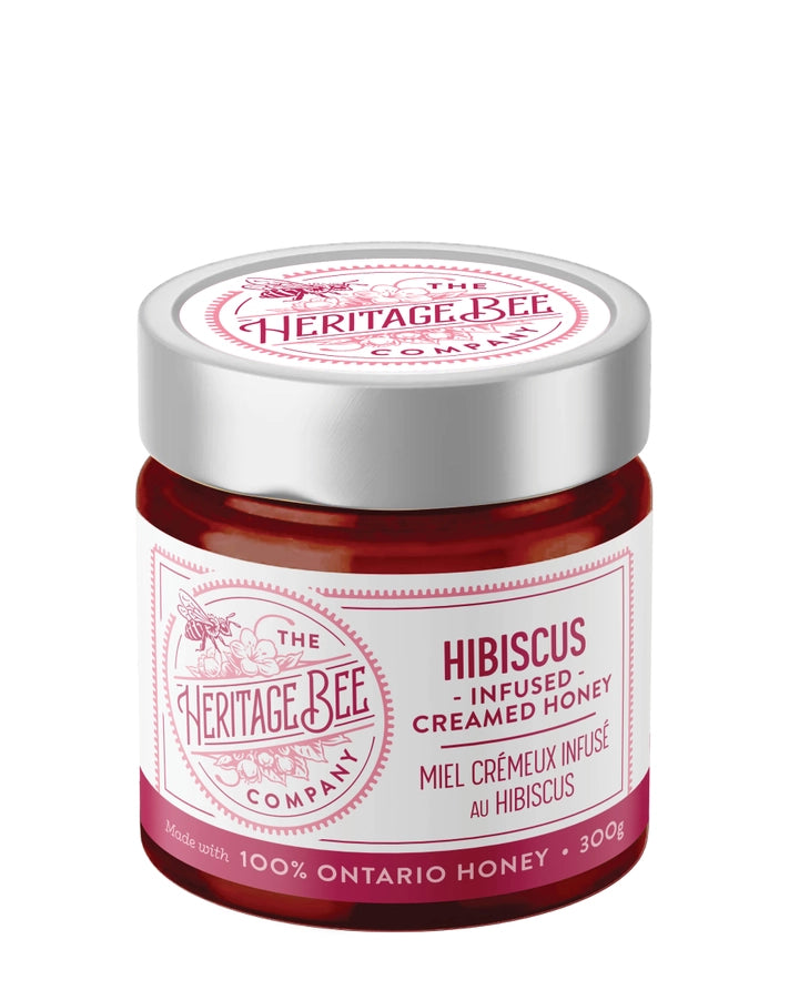 Jar of hibiscus-infused creamed honey from The Heritage Bee Company on a white background