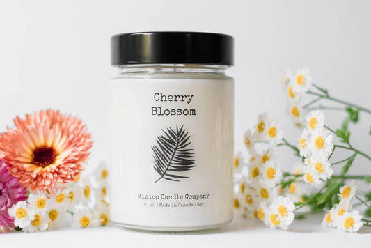 Candle jar labeled 'Cherry Blossom' with flowers on a white background