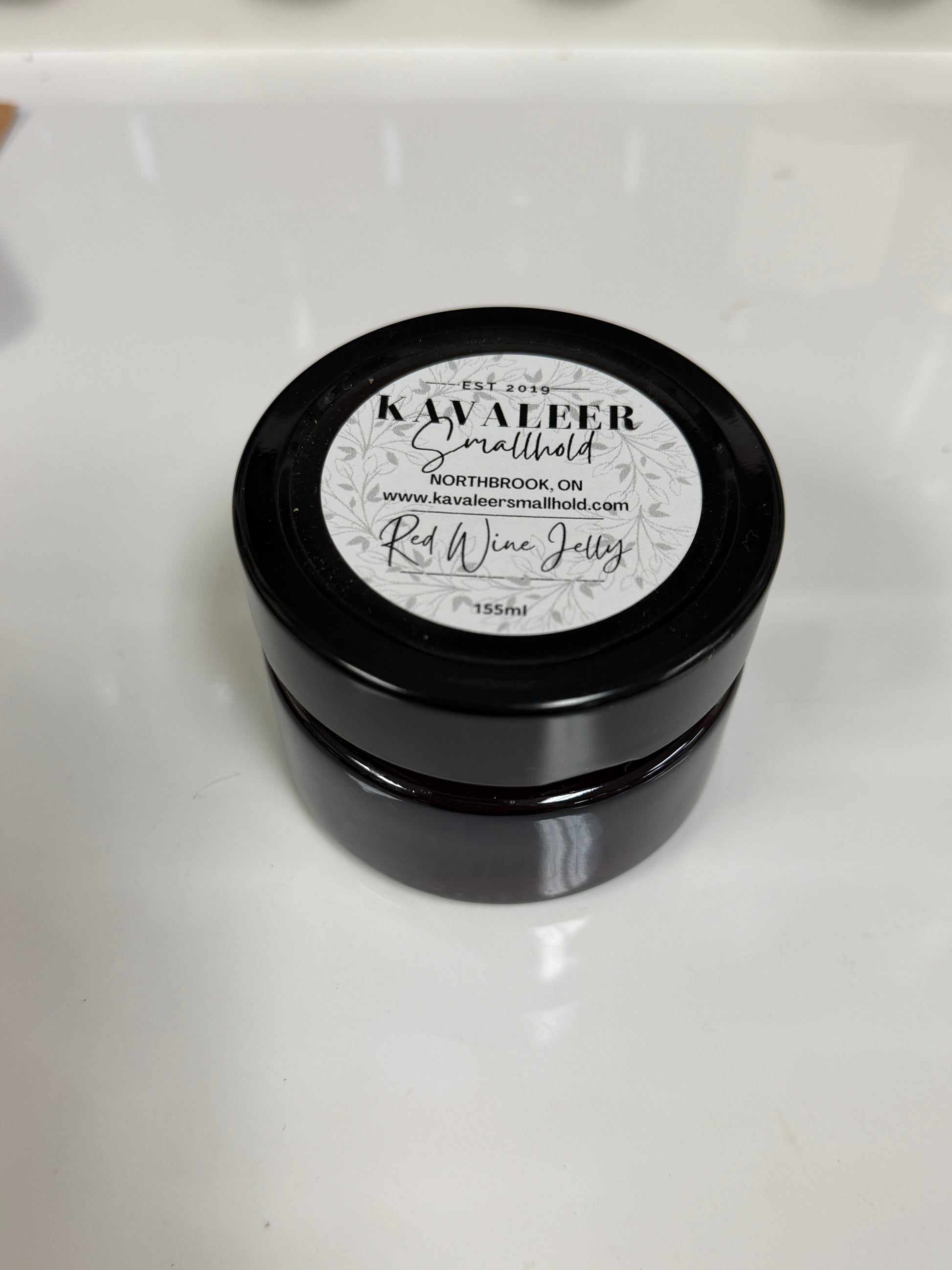 Black jar with a white label on a white background