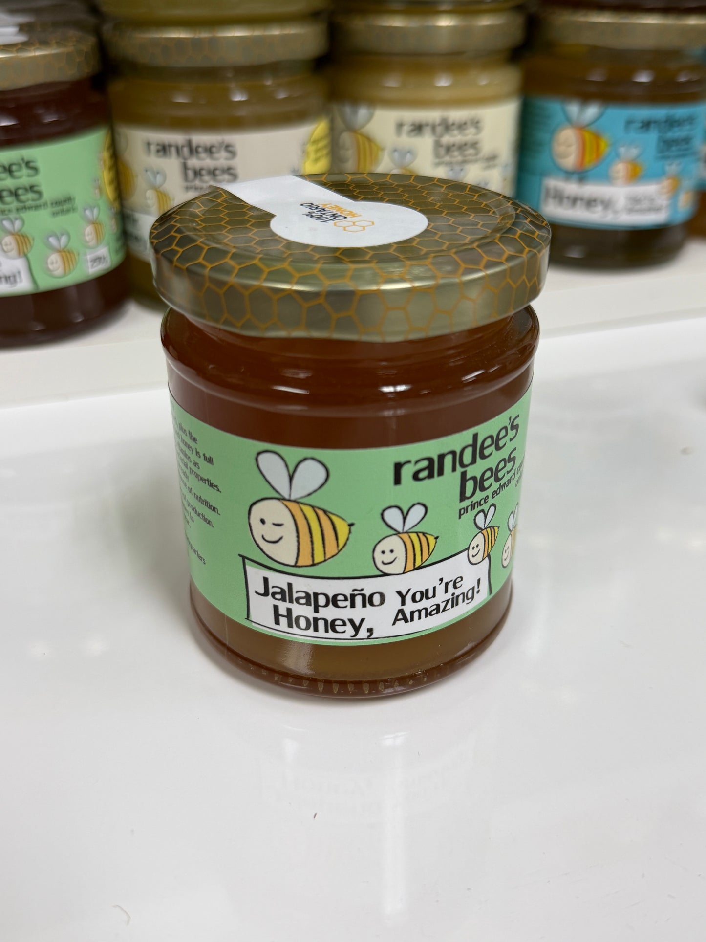 Jar of Randee's Bees Jalapeno Honey on a white surface