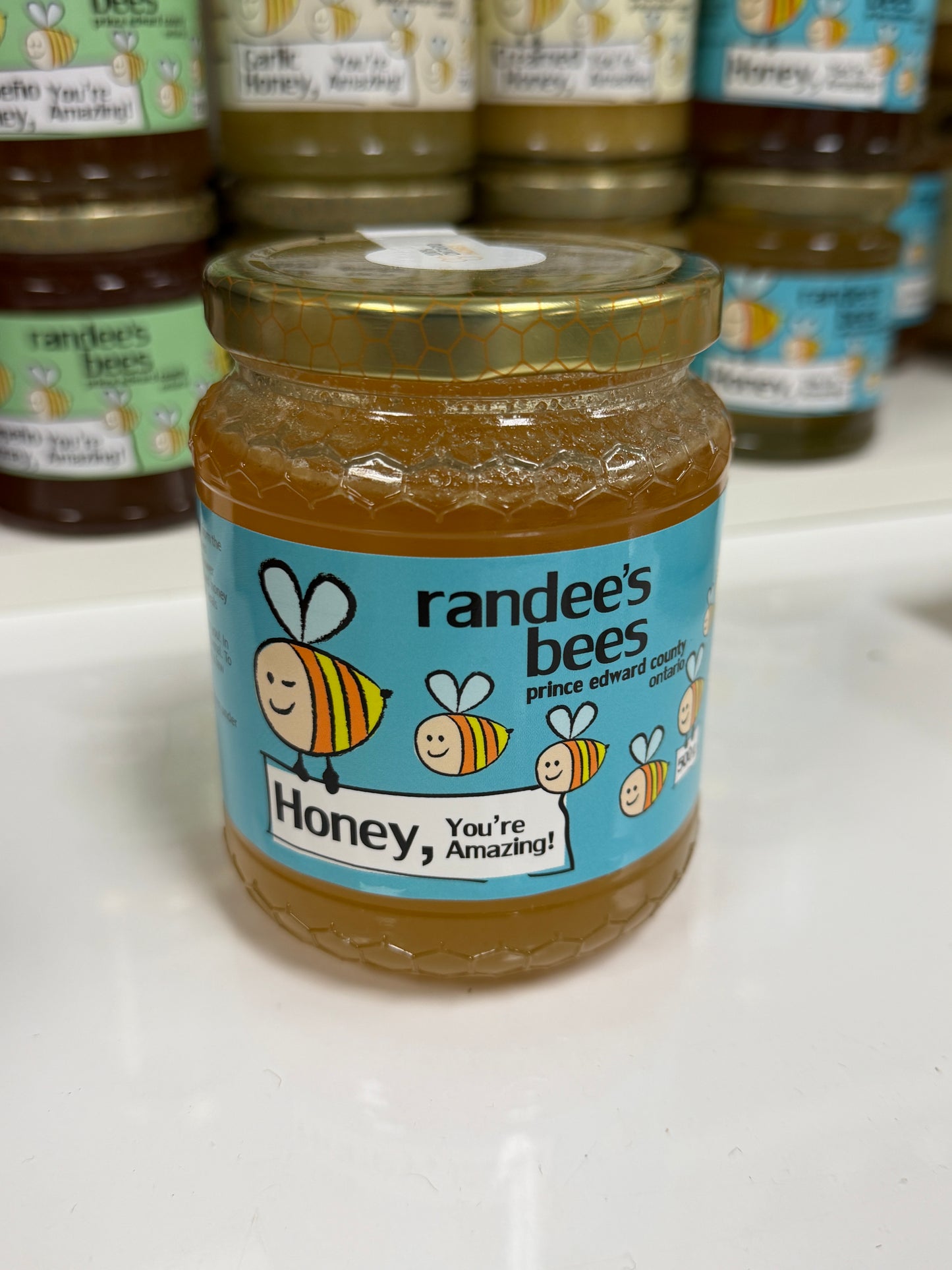 Jar of honey with a 'randee's bees' label on a white surface