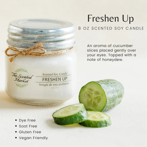 Scented soy candle labeled 'Freshen Up' with cucumber slices on a light background